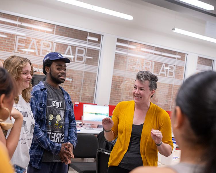 Professor and students discussing tasks in the Fab Lab.