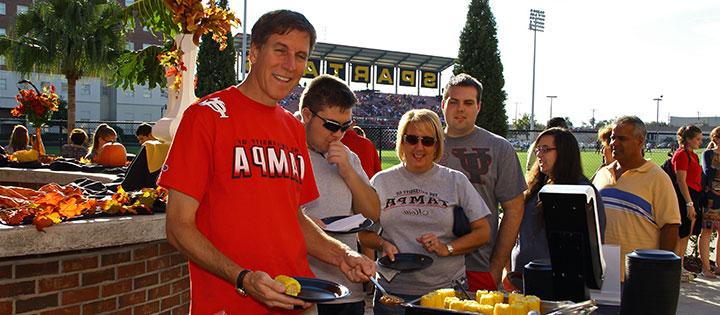 People standing outside in a buffet line